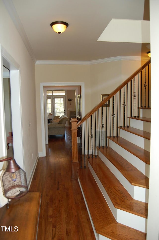 interior space with stairs, dark wood-type flooring, baseboards, and crown molding