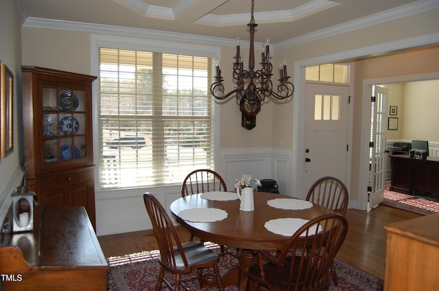 dining space with a decorative wall, a notable chandelier, dark wood-style flooring, ornamental molding, and wainscoting