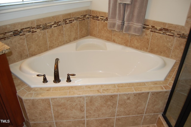 full bathroom with a garden tub and vanity