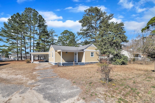 view of front of home featuring a carport, fence, and driveway