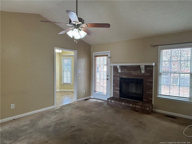 unfurnished living room with lofted ceiling, a brick fireplace, and carpet