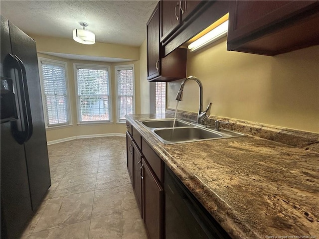 kitchen with black fridge, sink, dark brown cabinets, and a textured ceiling