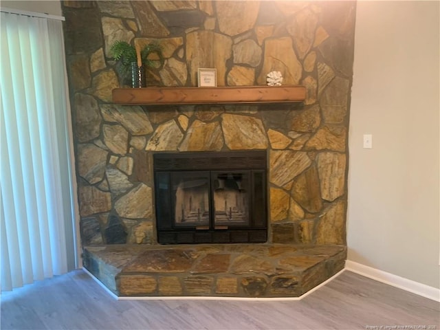 interior details with wood-type flooring and a fireplace