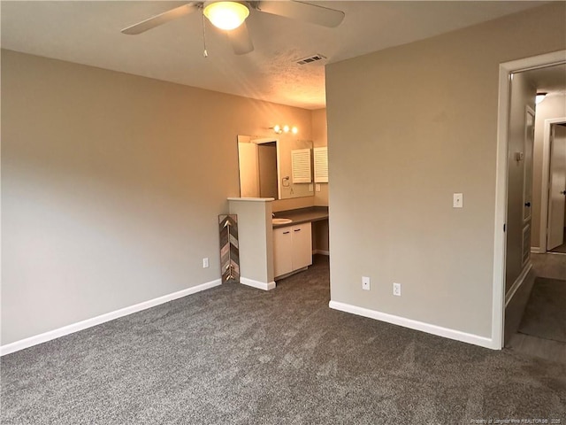 unfurnished bedroom with dark colored carpet and ceiling fan