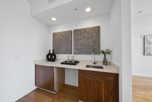 bar featuring sink and light hardwood / wood-style floors