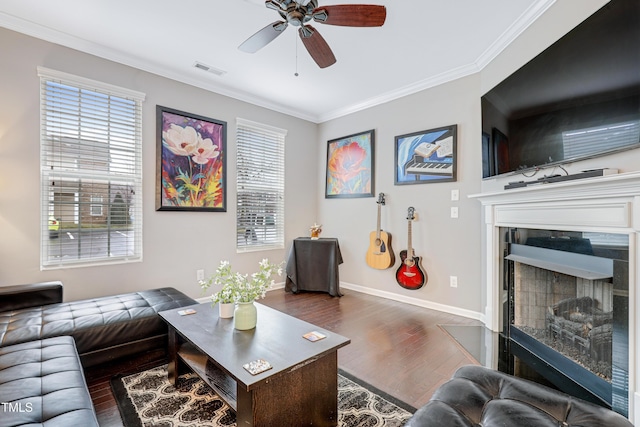 living area with ornamental molding, a wealth of natural light, dark wood-style flooring, and visible vents