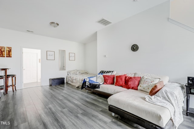 living area featuring visible vents and wood finished floors