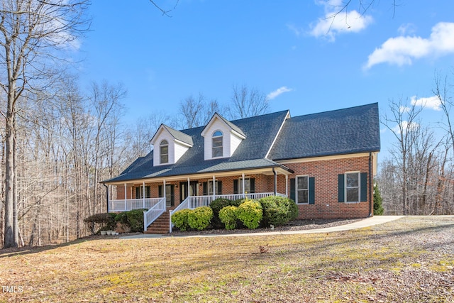 cape cod home featuring a front lawn and a porch