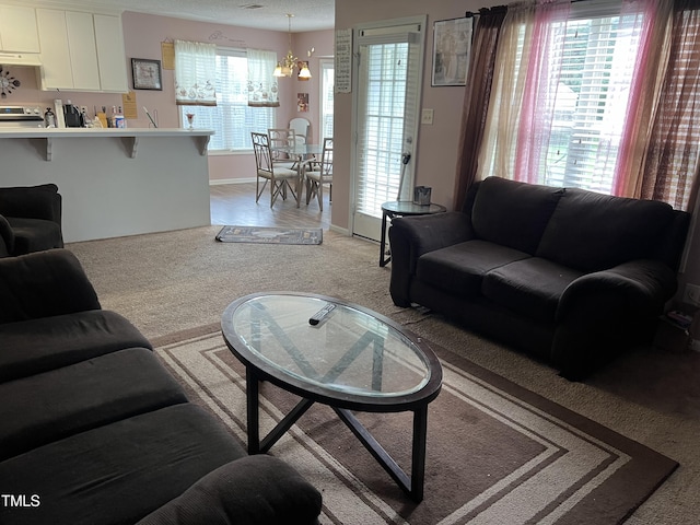 carpeted living room featuring a notable chandelier