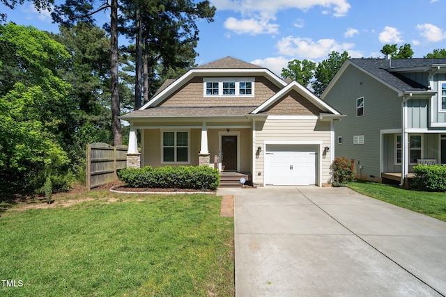 craftsman-style home with a front yard, fence, a porch, an attached garage, and concrete driveway