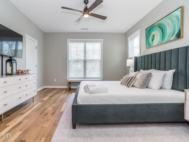 bedroom with visible vents, baseboards, light wood-style floors, and a ceiling fan