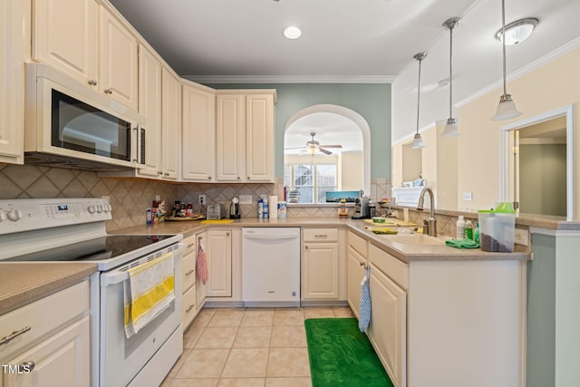 kitchen featuring arched walkways, white appliances, a sink, and crown molding