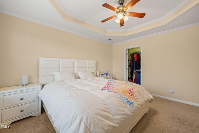 bedroom with light carpet, baseboards, a raised ceiling, a spacious closet, and crown molding