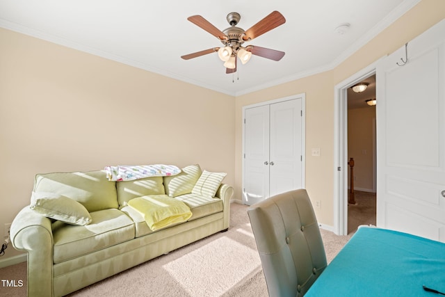 living room featuring baseboards, ornamental molding, ceiling fan, and carpet flooring