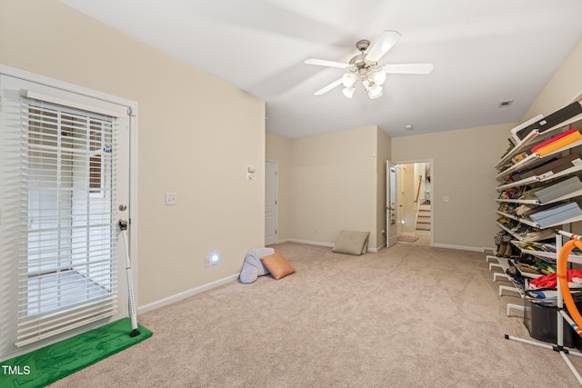 interior space with carpet flooring, a ceiling fan, and baseboards