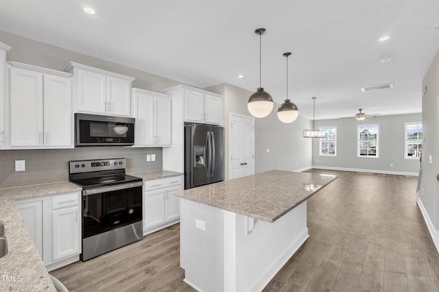 kitchen featuring open floor plan, appliances with stainless steel finishes, visible vents, and white cabinetry