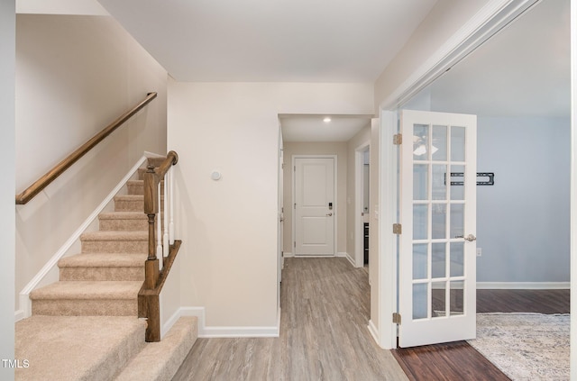 entrance foyer featuring baseboards, stairs, and wood finished floors