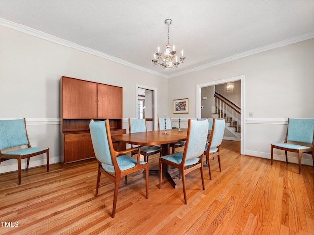 dining space with a notable chandelier, stairway, light wood-style floors, ornamental molding, and baseboards