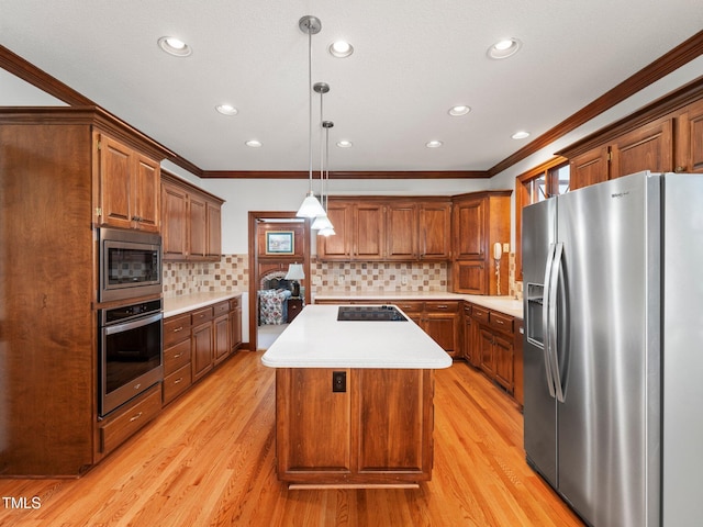 kitchen featuring light countertops, appliances with stainless steel finishes, a kitchen island, and pendant lighting