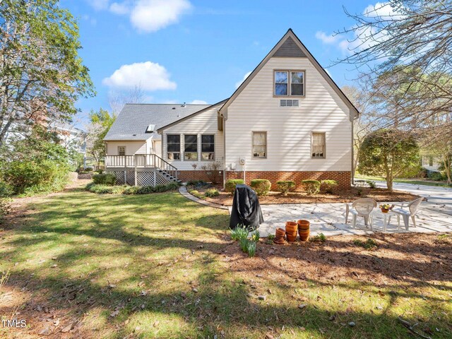 rear view of property with a wooden deck, stairs, a lawn, and a patio