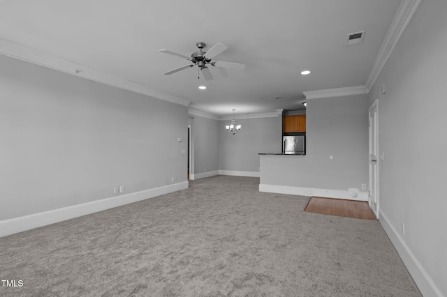 unfurnished living room with ceiling fan with notable chandelier, carpet flooring, visible vents, baseboards, and crown molding