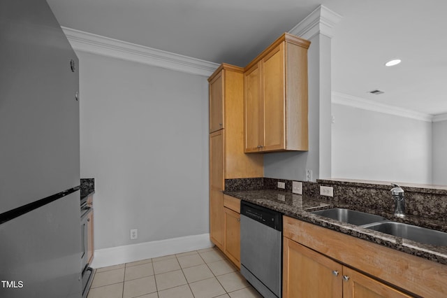 kitchen featuring crown molding, appliances with stainless steel finishes, light tile patterned flooring, a sink, and dark stone countertops