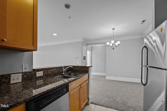 kitchen with stainless steel appliances, visible vents, light carpet, a sink, and dark stone countertops