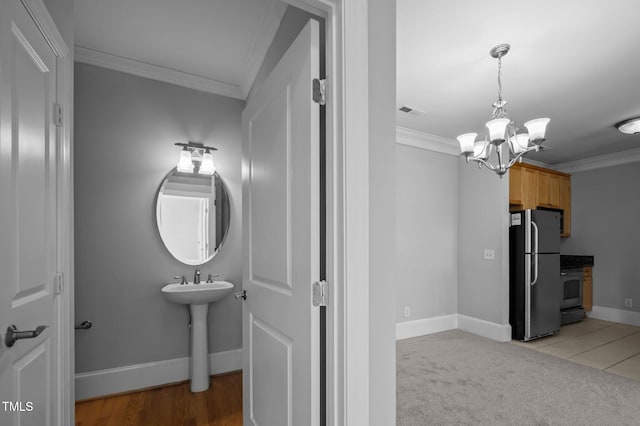 bathroom with visible vents, crown molding, a notable chandelier, and baseboards