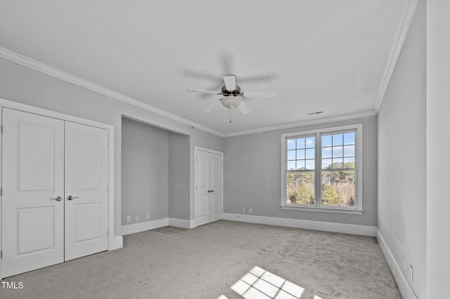 unfurnished bedroom featuring light carpet, visible vents, baseboards, a ceiling fan, and crown molding