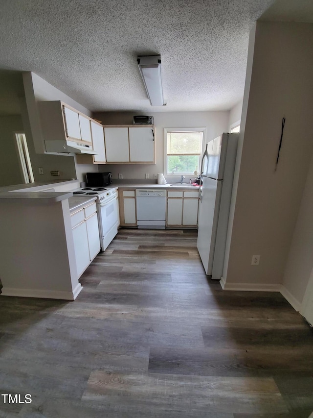 kitchen with light countertops, white appliances, dark wood finished floors, and white cabinets