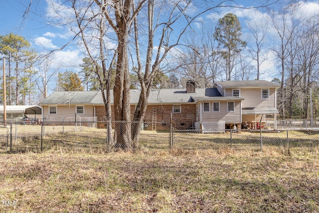 rear view of house with a fenced backyard, brick siding, crawl space, a detached carport, and a chimney