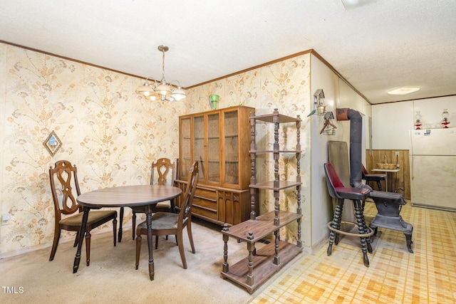 carpeted dining room featuring crown molding, a textured ceiling, a notable chandelier, and wallpapered walls