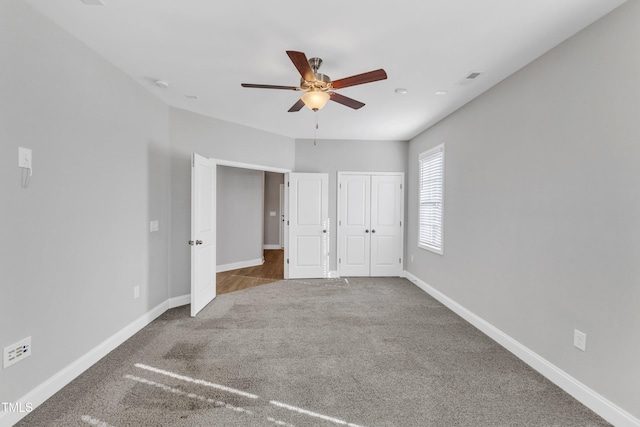 unfurnished bedroom with carpet, a closet, baseboards, and a ceiling fan