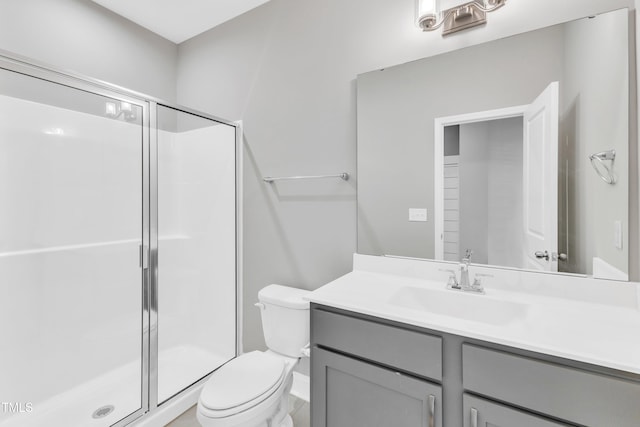 bathroom with a stall shower, vanity, and toilet