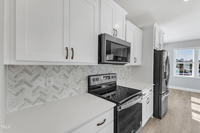 kitchen with light countertops, appliances with stainless steel finishes, white cabinetry, and decorative backsplash