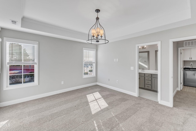 interior space featuring light carpet, visible vents, a chandelier, and a tray ceiling