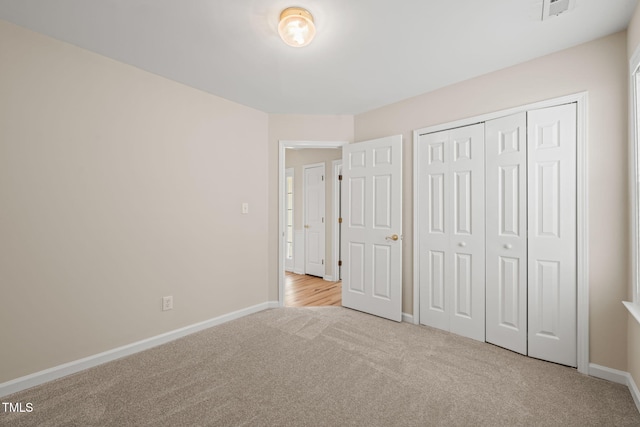 unfurnished bedroom with carpet floors, baseboards, and a closet