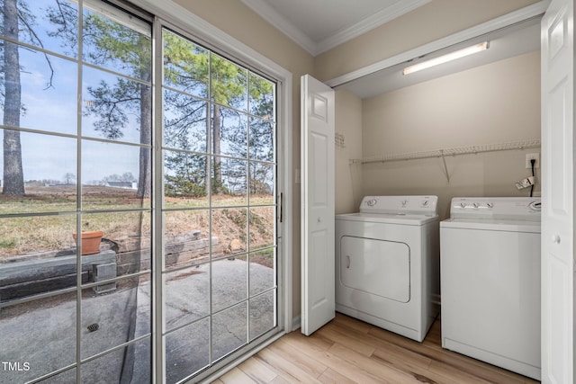 laundry room with light wood finished floors, laundry area, ornamental molding, and washing machine and clothes dryer