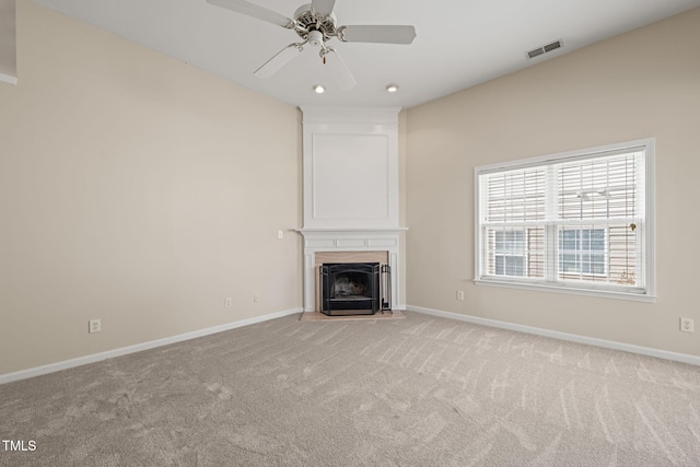 unfurnished living room featuring baseboards, a fireplace, visible vents, and light colored carpet