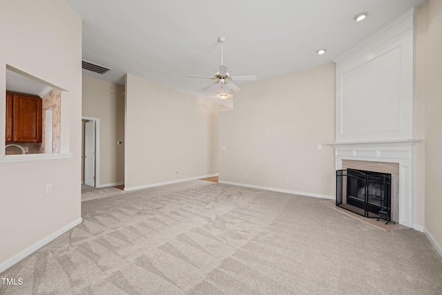 unfurnished living room featuring light carpet, baseboards, visible vents, a ceiling fan, and a fireplace