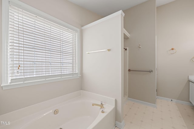 bathroom featuring a garden tub, baseboards, and tile patterned floors