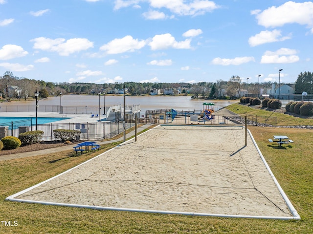 surrounding community with a yard, a water view, fence, and volleyball court