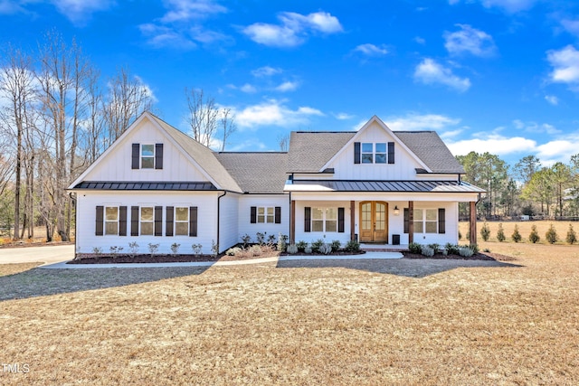 modern inspired farmhouse featuring board and batten siding, covered porch, roof with shingles, and a standing seam roof