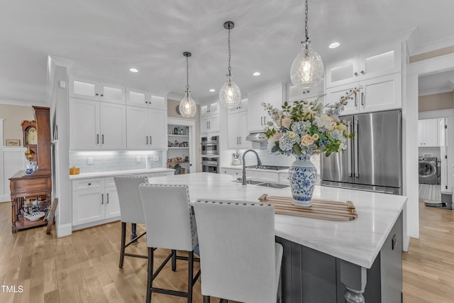 kitchen featuring stainless steel appliances, a spacious island, and glass insert cabinets