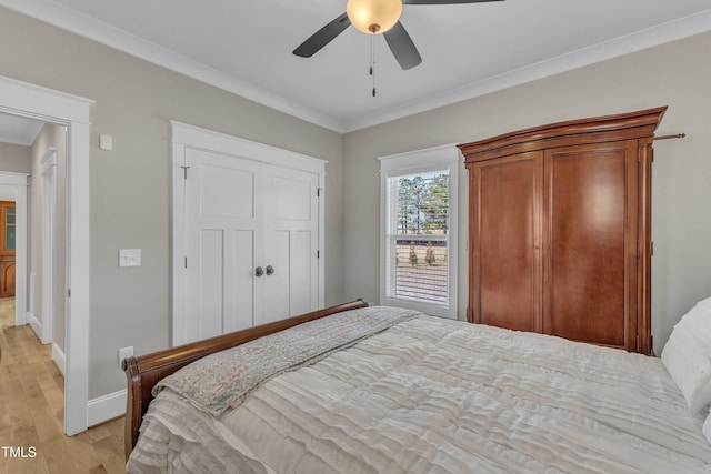 bedroom featuring light wood finished floors, a ceiling fan, baseboards, and crown molding