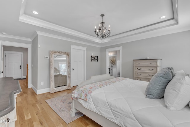 bedroom featuring ornamental molding, light wood finished floors, a raised ceiling, and baseboards