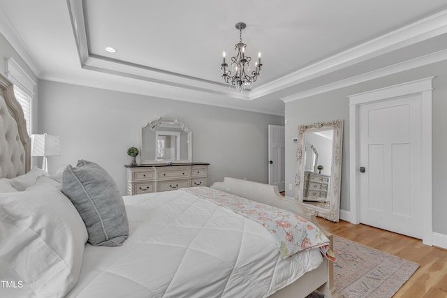 bedroom featuring light wood-style floors, a tray ceiling, and crown molding