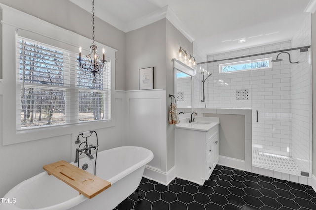 full bathroom featuring a wainscoted wall, crown molding, a freestanding bath, a shower stall, and vanity