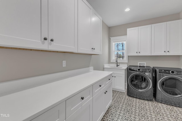 washroom featuring cabinet space, recessed lighting, a sink, and washing machine and clothes dryer