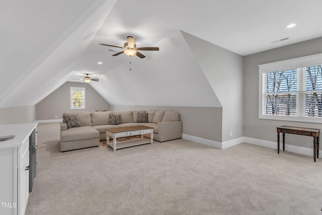 living area featuring light carpet, visible vents, baseboards, and lofted ceiling